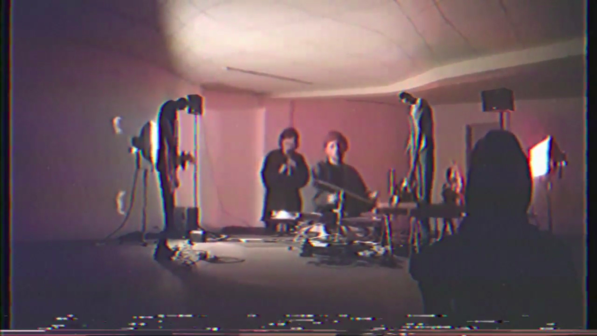 a very distorted image of the 4-piece lineup performing in an arts space